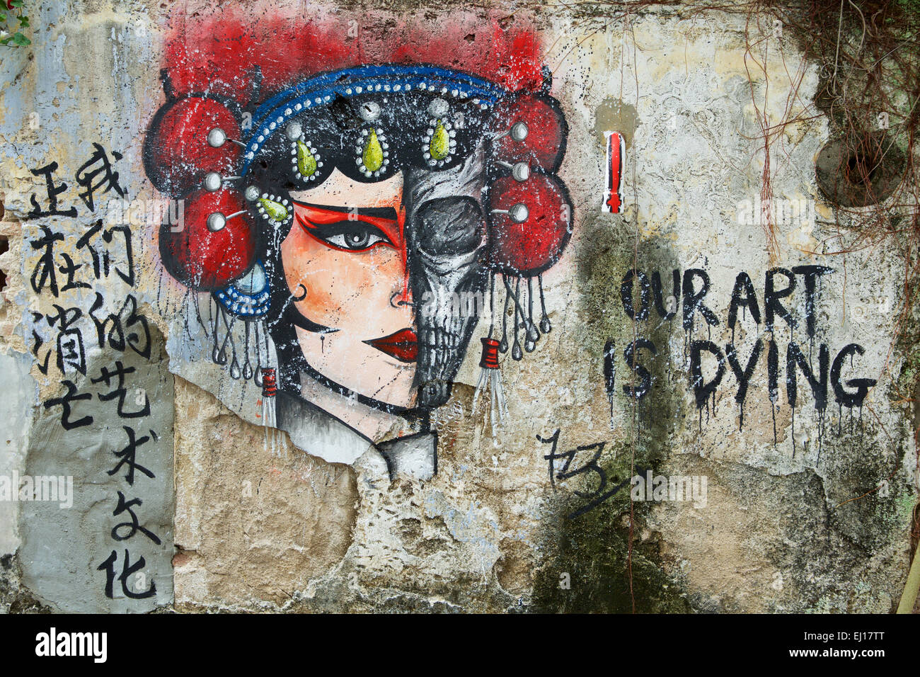 Anonimo arte di strada in Georgetown Penang. Strano murale di protesta con il messaggio che l'arte sta morendo. Metà cranio e metà faccia. Foto Stock