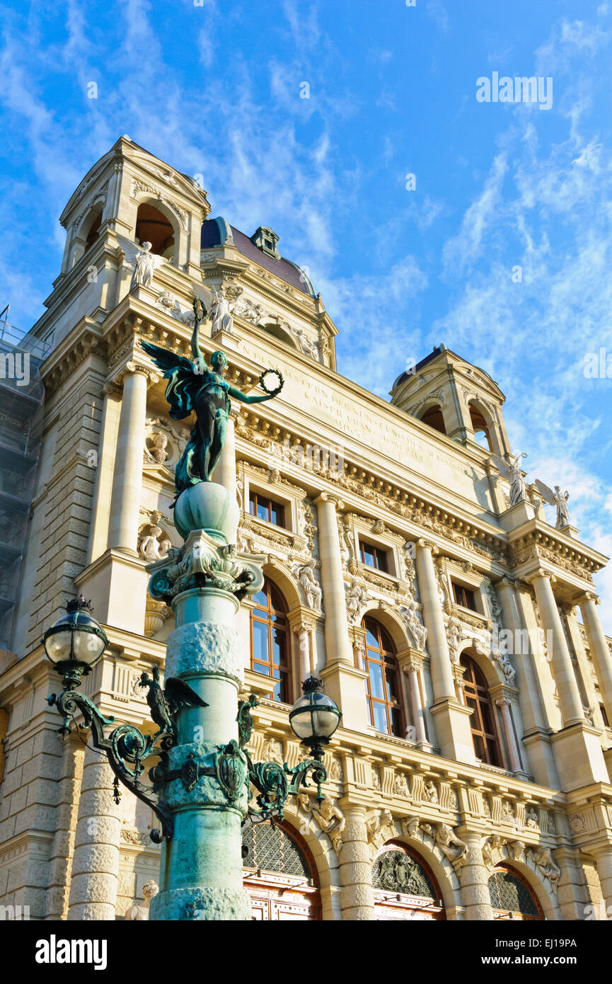 Una femmina di angelo azienda due corone di fiori in aria sulla cima di un lampione vintage di fronte al Museo di Storia dell'arte, Vienna. Foto Stock