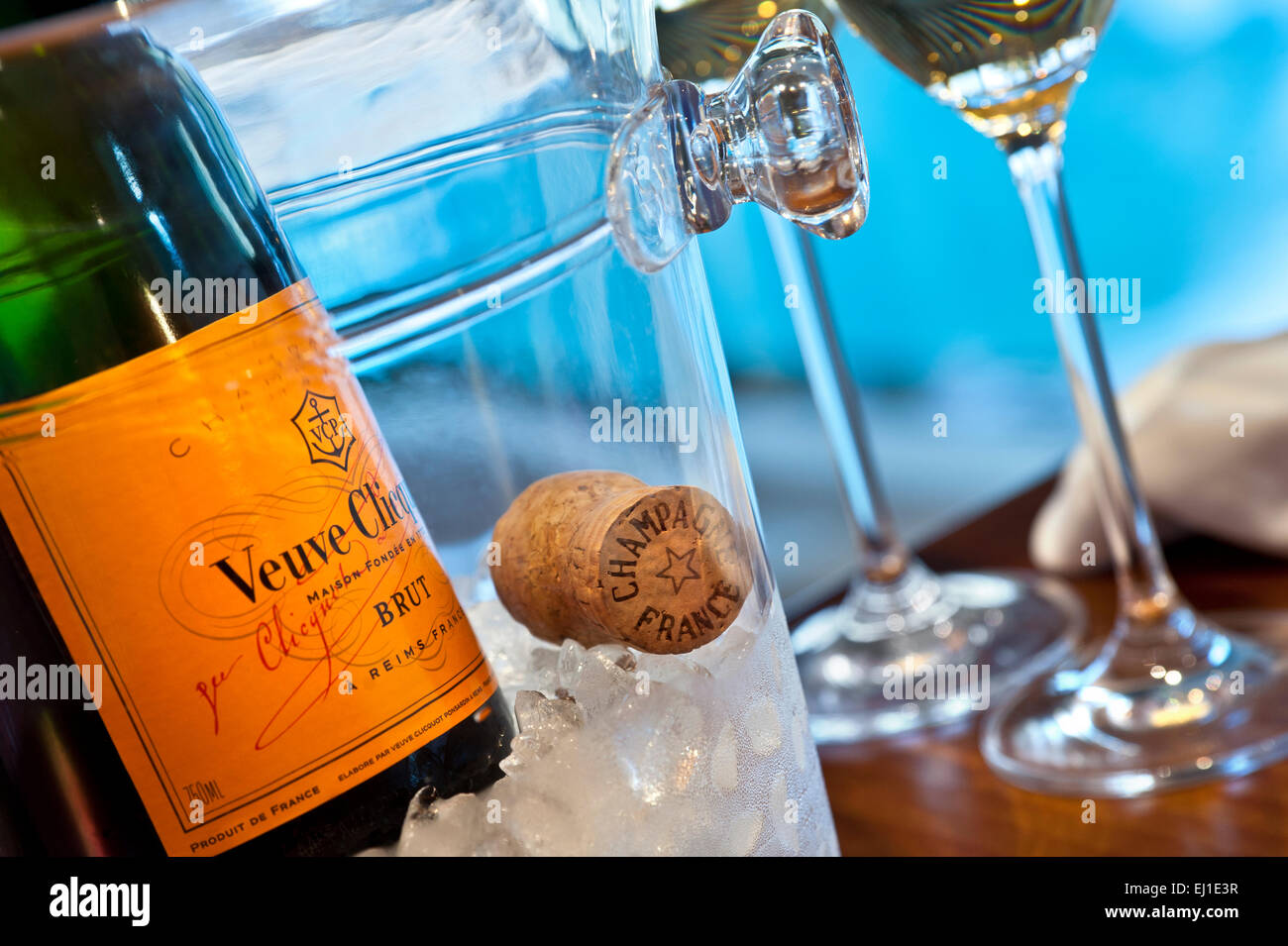 Chiudere la vista su Veuve Clicquot Fine Champagne bottiglia su ghiaccio con sughero e bicchieri, piscina di lusso in background Foto Stock