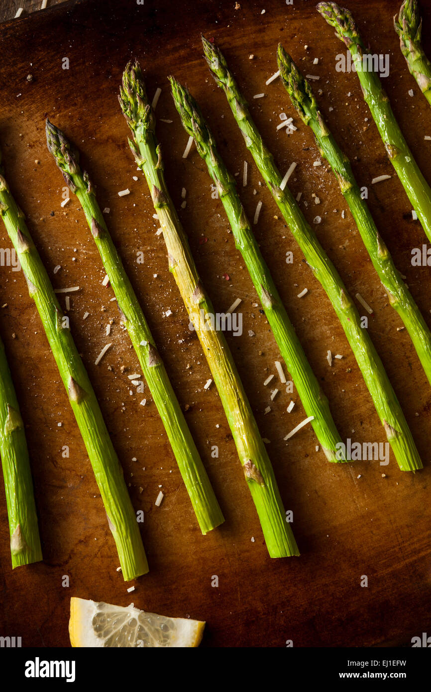 In casa cuocere gli asparagi verdi con limone e formaggio Foto Stock