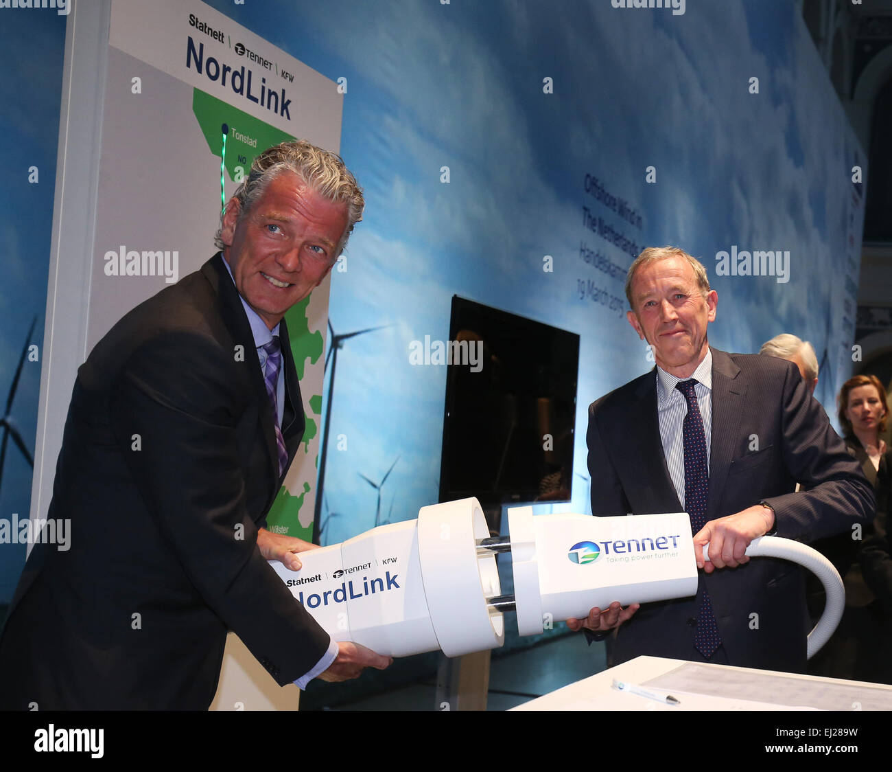 Amburgo, Germania. Xix Mar, 2015. Il CEO di Norwegian operatore di trasmissione Statnett, Auke Lont (L) e il CEO di Tennet, Mel Kroon, collegare un potere simbolico il tappo dopo la firma del contratto German-Norwegian per la linea di alimentazione di potenza Nordlink durante un ricevimento presso il Seminario Trilaterale " Energia eolica offshore nei Paesi Bassi, in Germania e in Danimarca, un contributo per la Comunità europea dell'energia Transizione" presso la Camera di commercio di Amburgo, Germania, 19 marzo 2015. L'Olandese royal giovane è su una visita di lavoro di due giorni per la Germania settentrionale. Foto: Christian Charisius/dpa/Alamy Live News Foto Stock