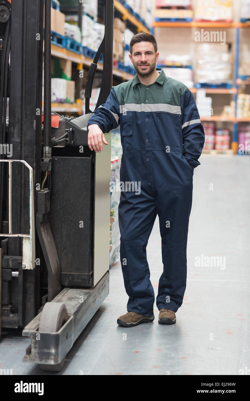 Lavoratore manuale appoggiata contro il carrello elevatore a forche Foto Stock