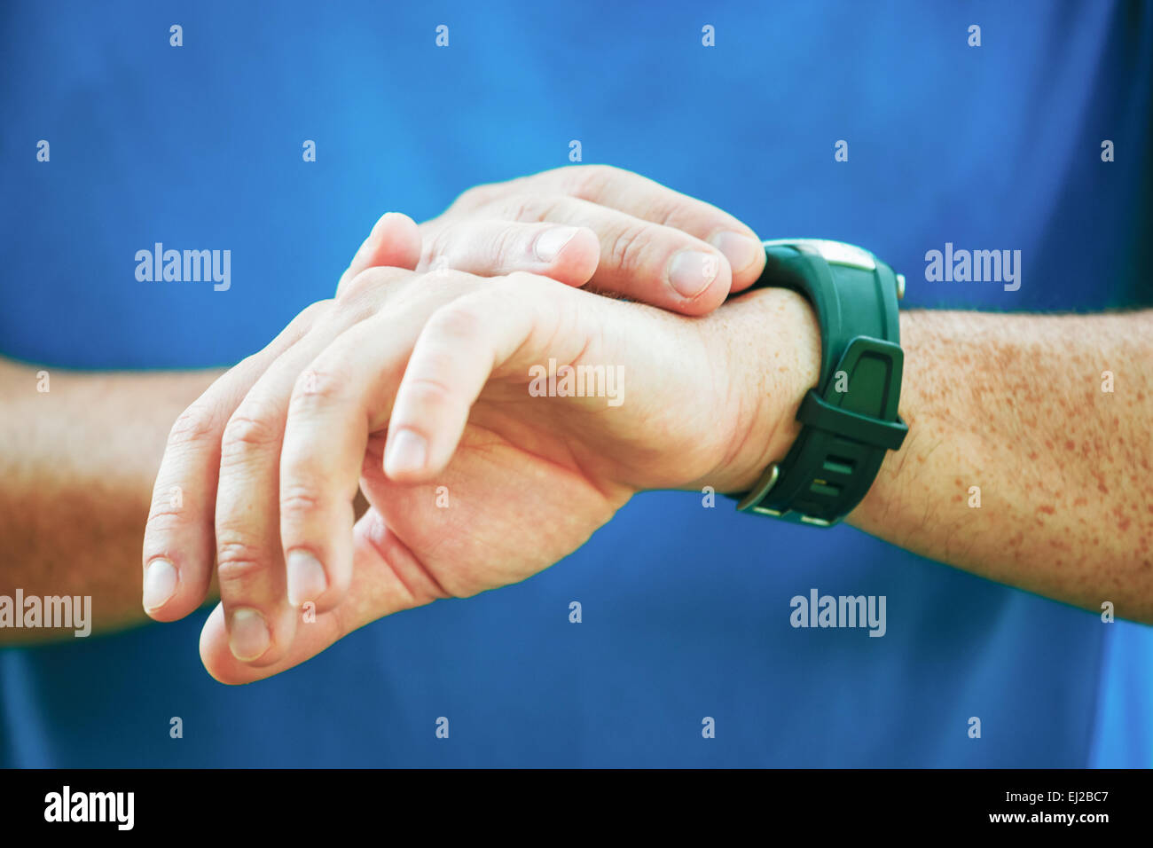 Runner maschio guardando al suo monitor frequenza cardiaca. Foto Stock