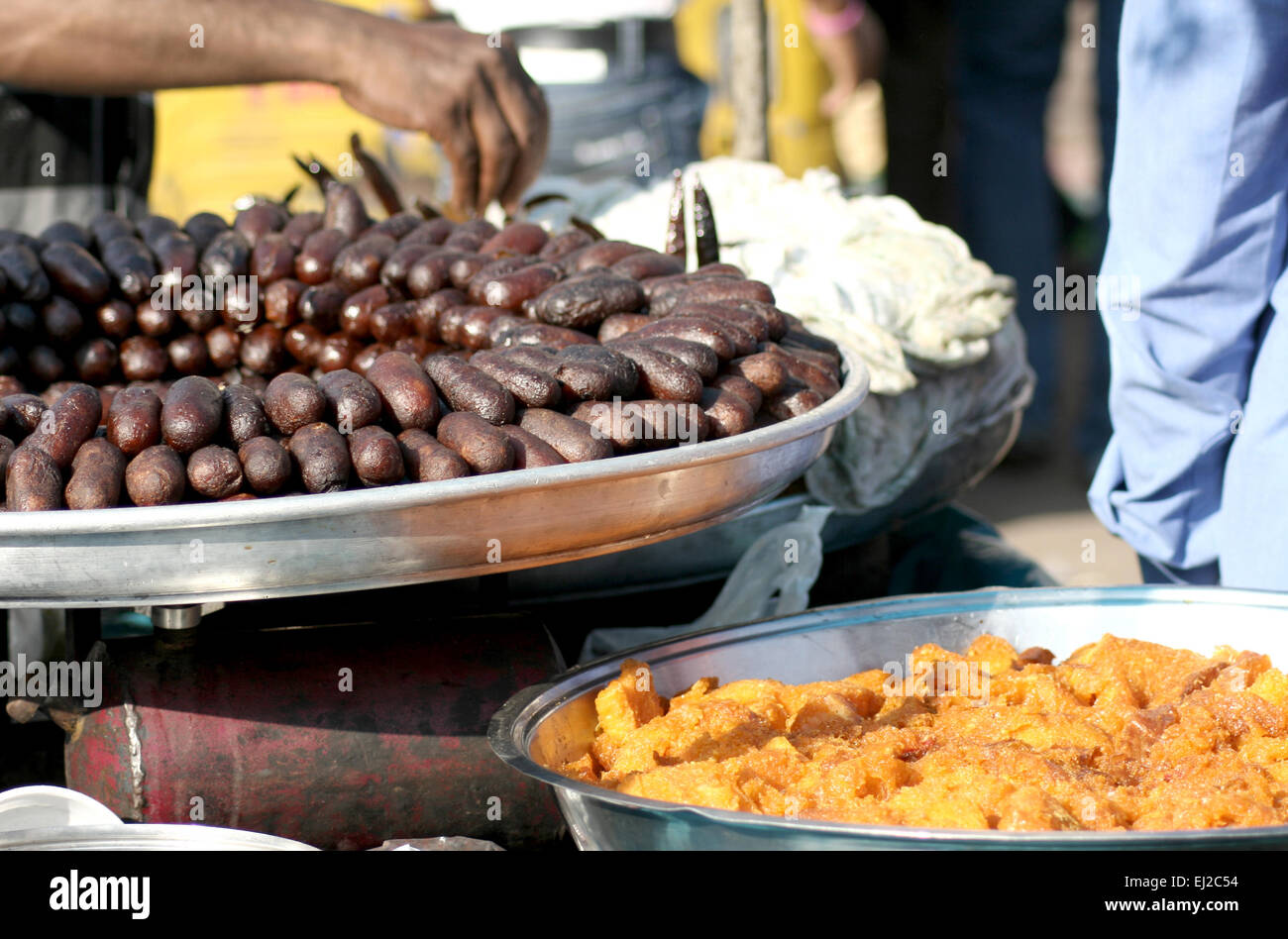 Indian venditore ambulante vendere Gulab Jamun e halwa in una affollata strada a novembre 15,2013 in Hyderabad, India. Foto Stock