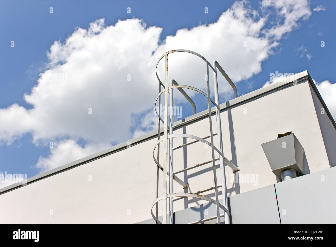 Sicurezza scaletta di metallo al tetto e cielo blu Foto Stock