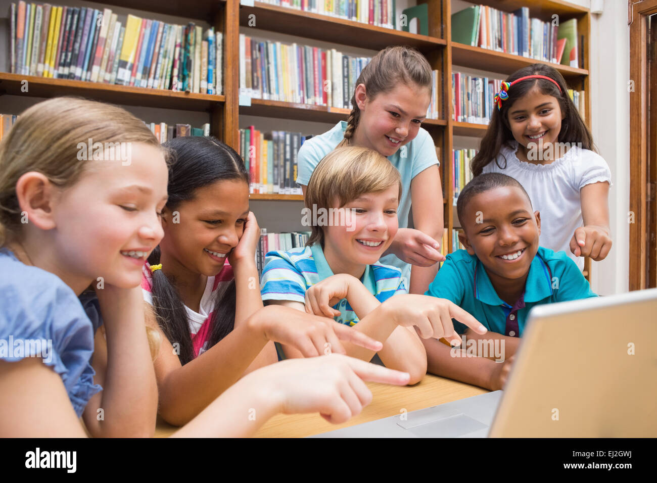 Carino gli studenti usando computer tablet in libreria Foto Stock