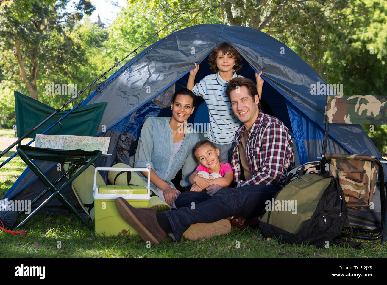 La famiglia felice su un viaggio di campeggio nella loro tenda Foto Stock