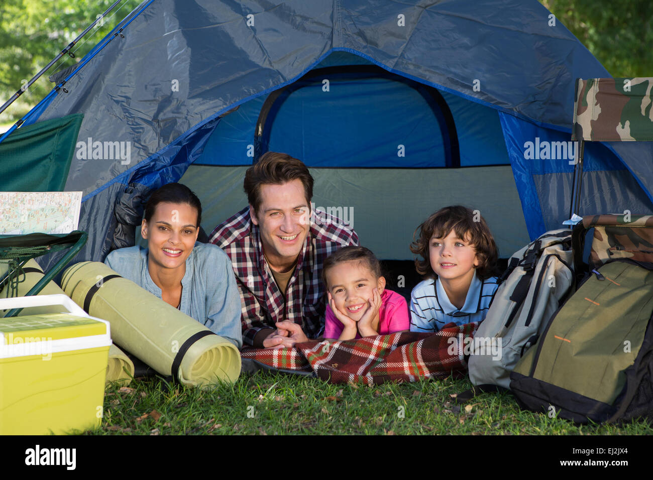 La famiglia felice su un viaggio di campeggio nella loro tenda Foto Stock