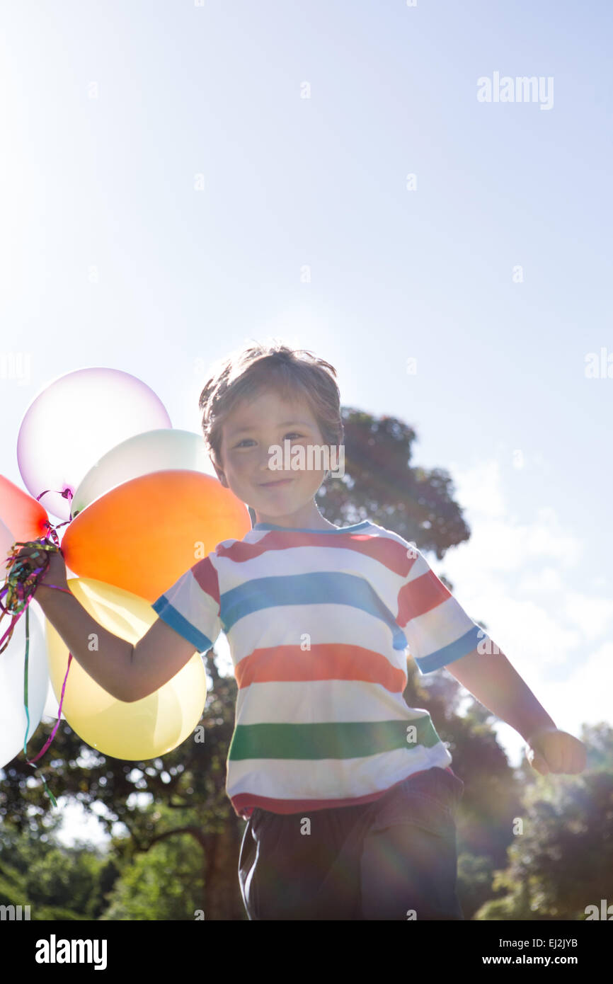 Happy little boy holding palloncini Foto Stock