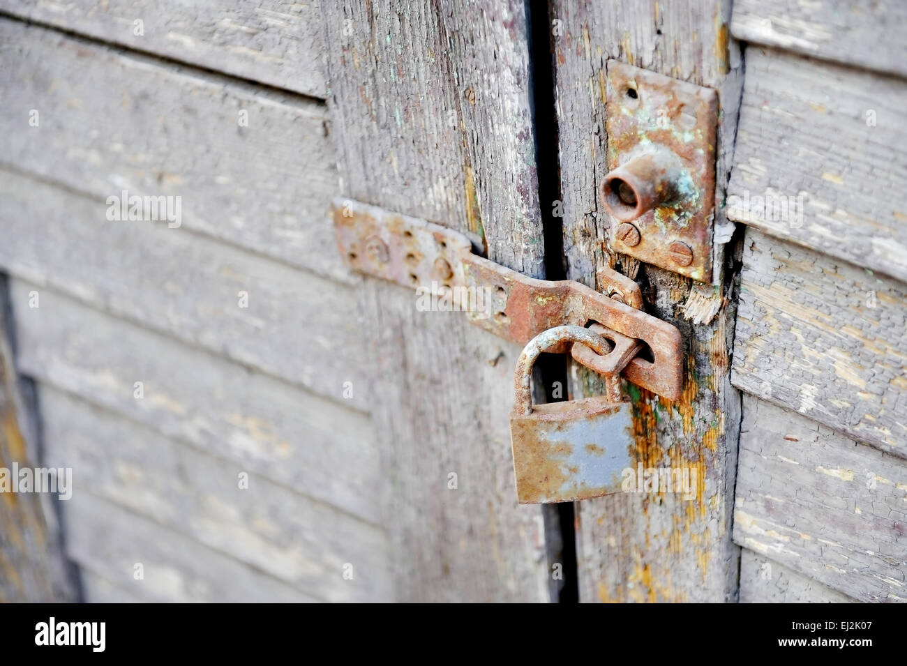 Vecchie e arrugginite serratura di una porta di legno Foto Stock