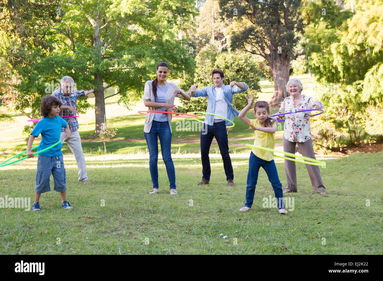 Famiglia estesa a giocare con hula hoops Foto Stock