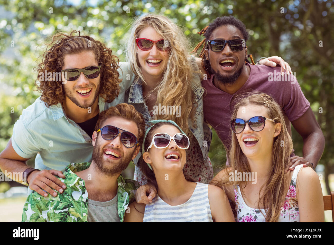 Happy amici sorridente in telecamera Foto Stock