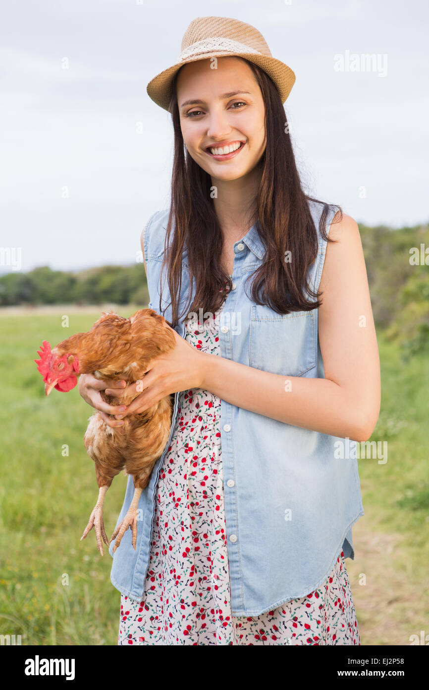Happy brunette tenendo il suo pollo Foto Stock