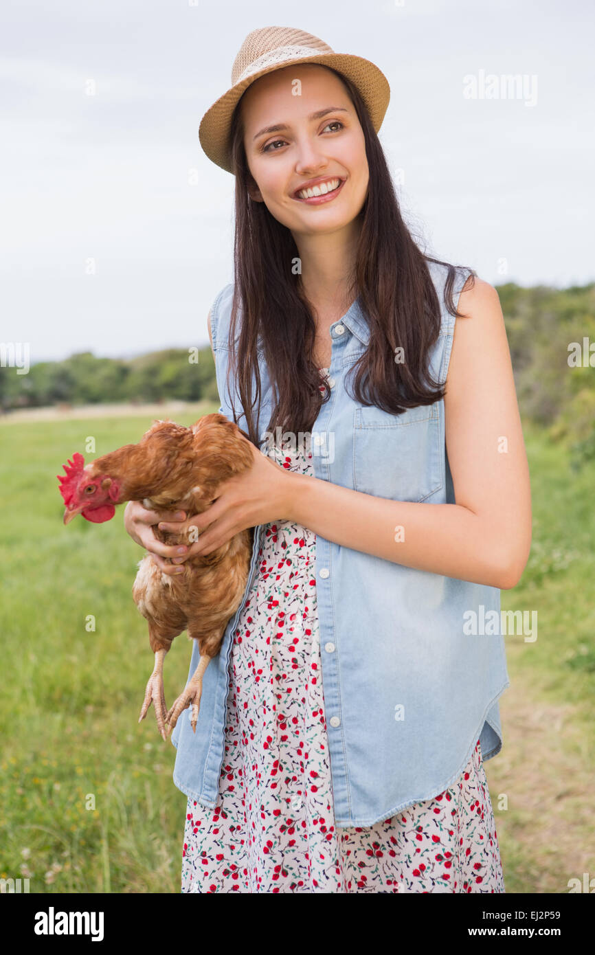 Happy brunette tenendo il suo pollo Foto Stock