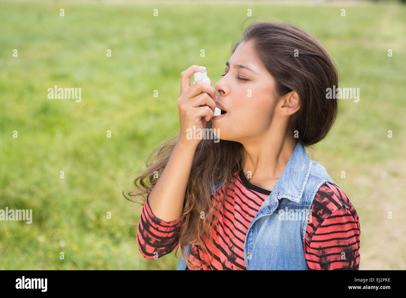 Bella bruna con il suo inalatore Foto Stock