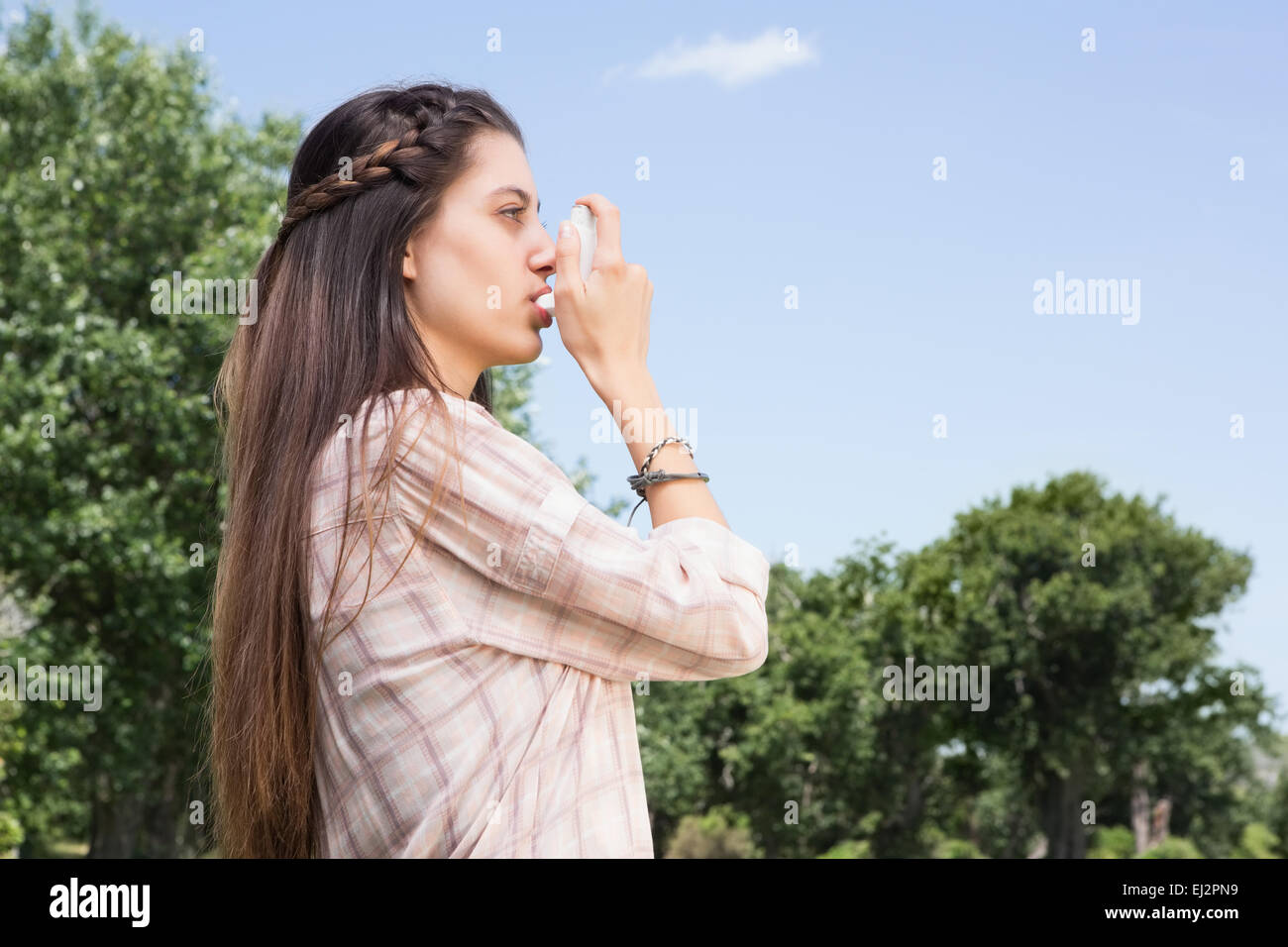 Bella bruna con il suo inalatore Foto Stock