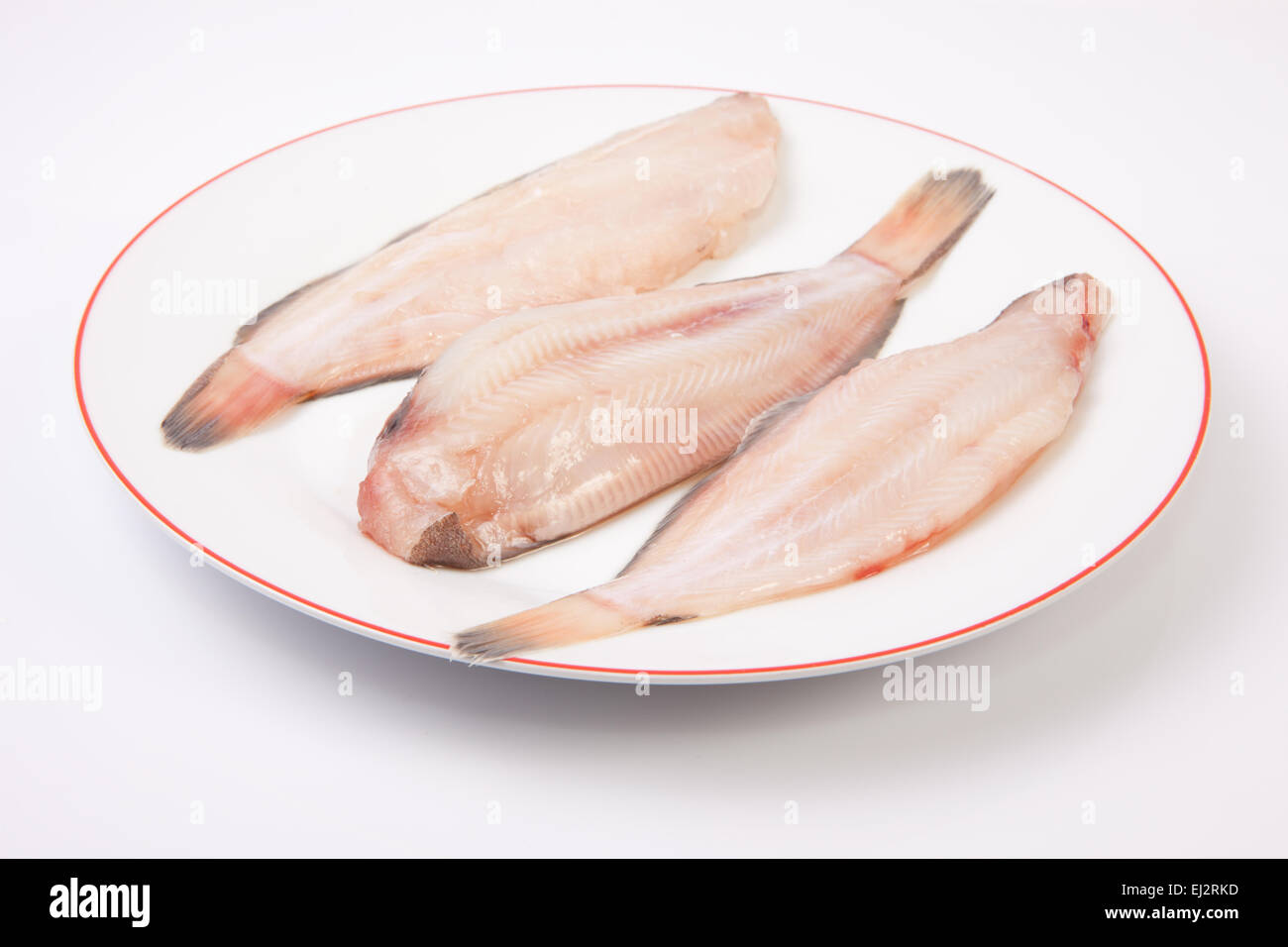 Materie suola pesci pronti per cucinare. Piastra di tre pezzi isolati su sfondo bianco Foto Stock