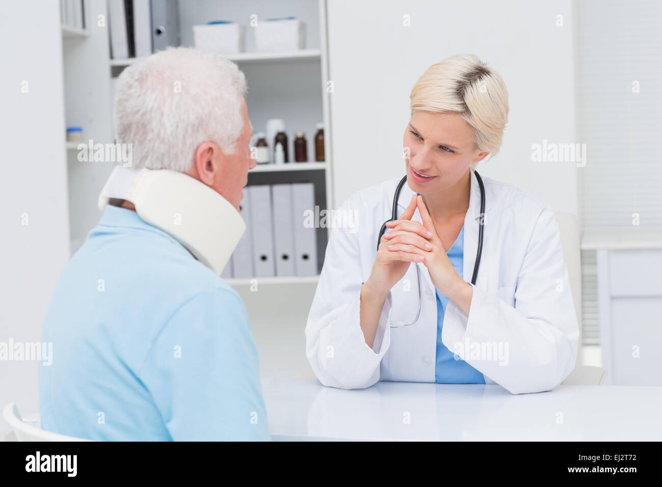 Medico guardando senior paziente che indossa il rinforzo del collo Foto Stock
