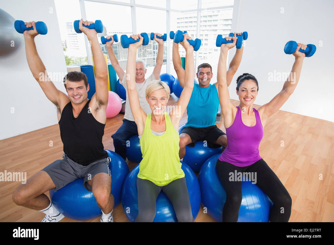 Persone il sollevamento pesi nella palestra di classe Foto Stock