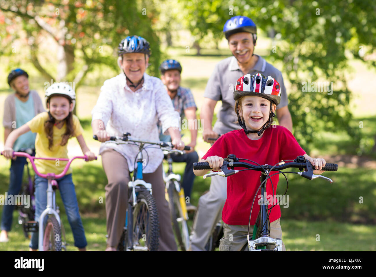 La famiglia felice in bicicletta nel parco Foto Stock