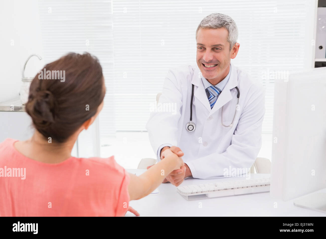 Felice handshake medico al suo paziente Foto Stock