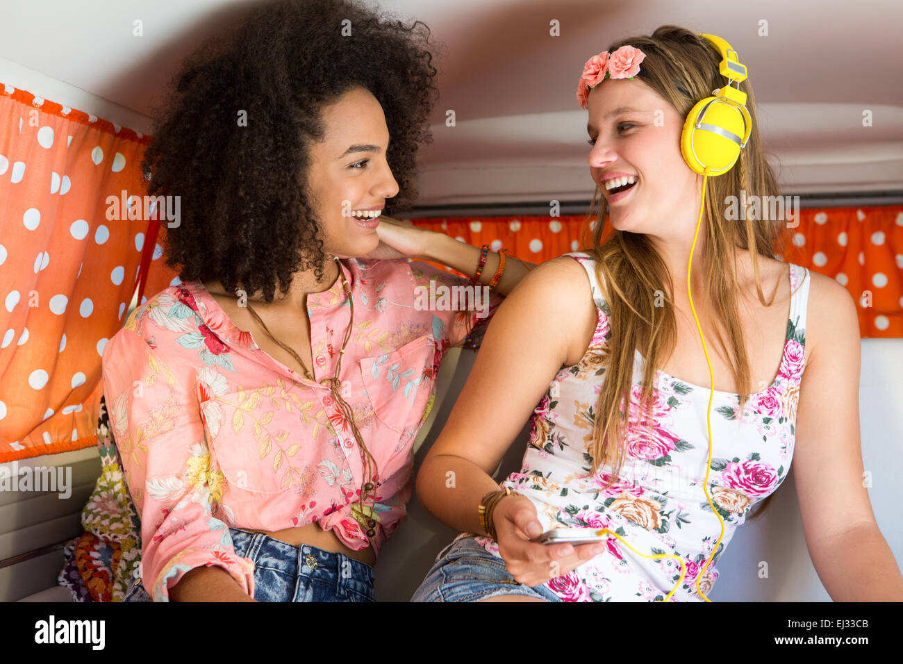 Happy amici su un viaggio utilizzando l'ascolto di musica Foto Stock