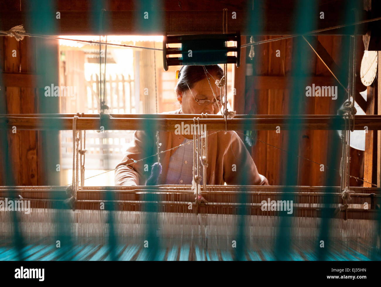 Una donna birmano seta tessitura su un telaio di tessitura, il villaggio di tessitura a Paw Khone, Lago Inle, Myanmar ( Birmania ), Asia Foto Stock