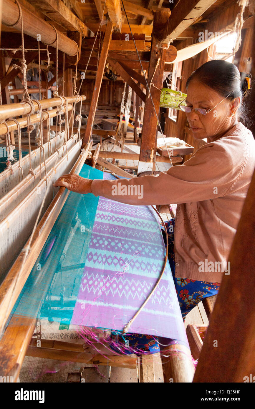 Una donna birmano la tessitura lotus filo di seta su di un telaio di tessitura, in Paw Khone village, Lago Inle, Myanmar ( Birmania ), Asia Foto Stock