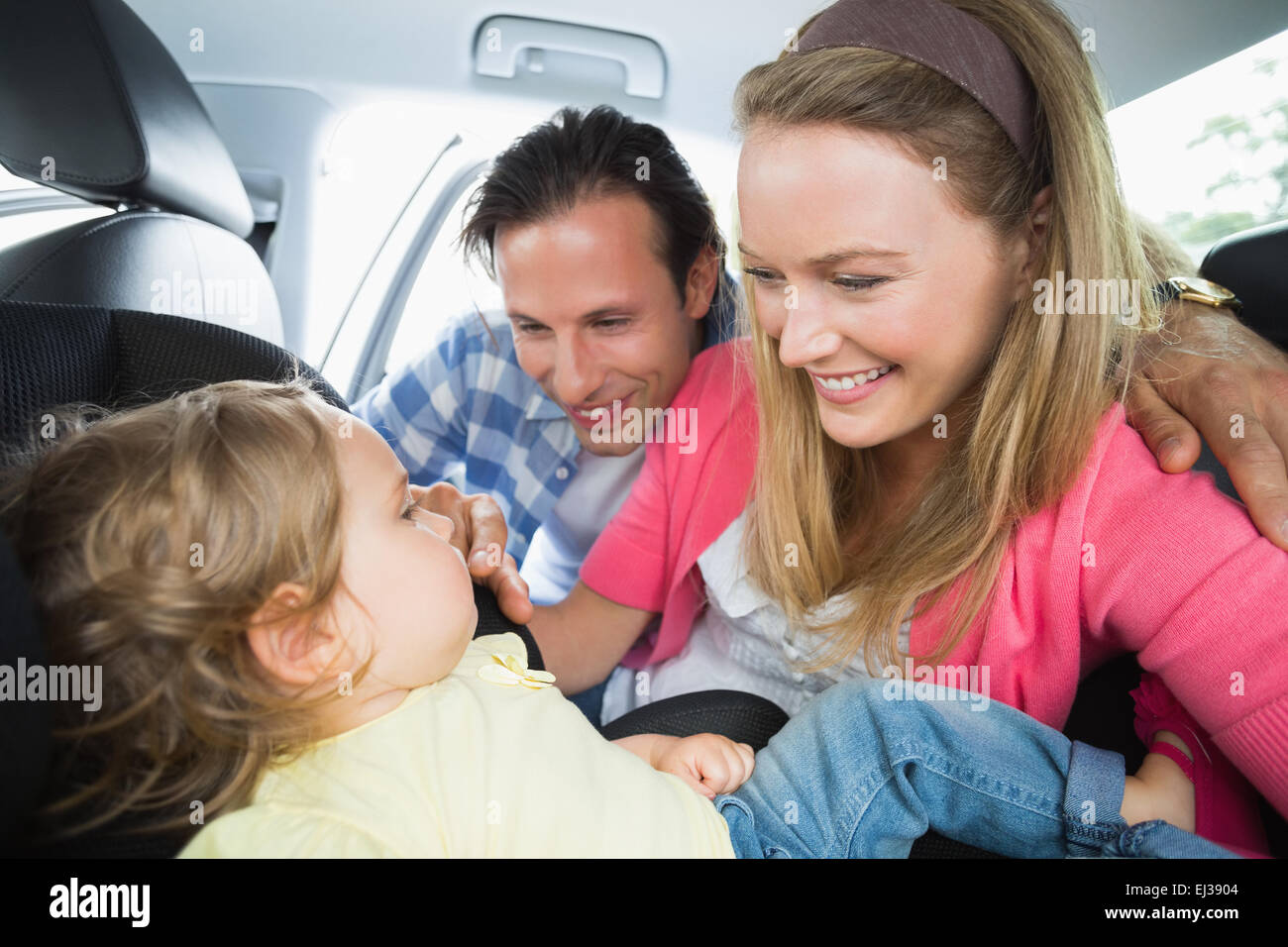 I genitori che fissano il bambino nel seggiolino per auto Foto Stock