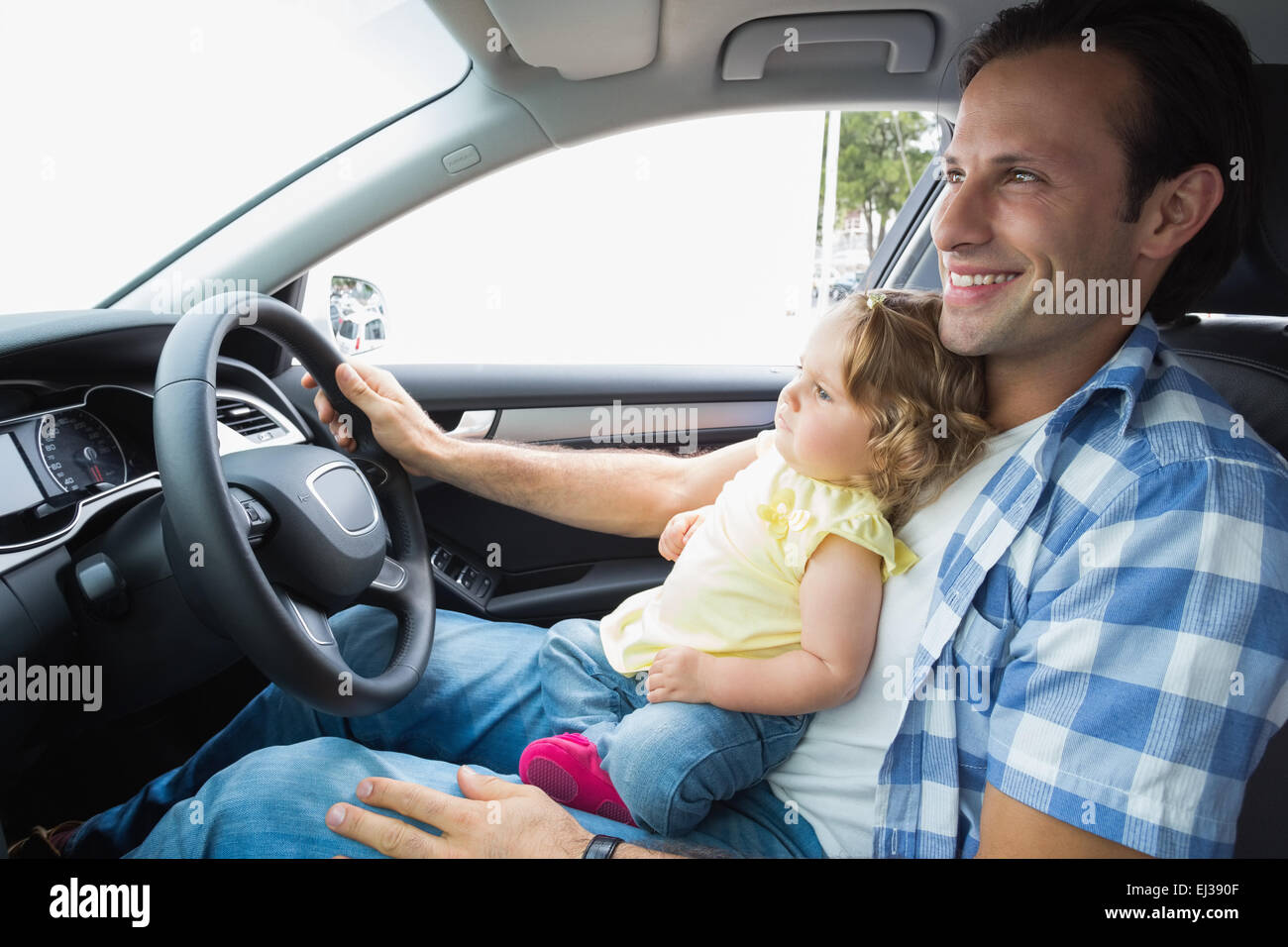 Padre giocando con il bambino nel sedile di guida Foto Stock