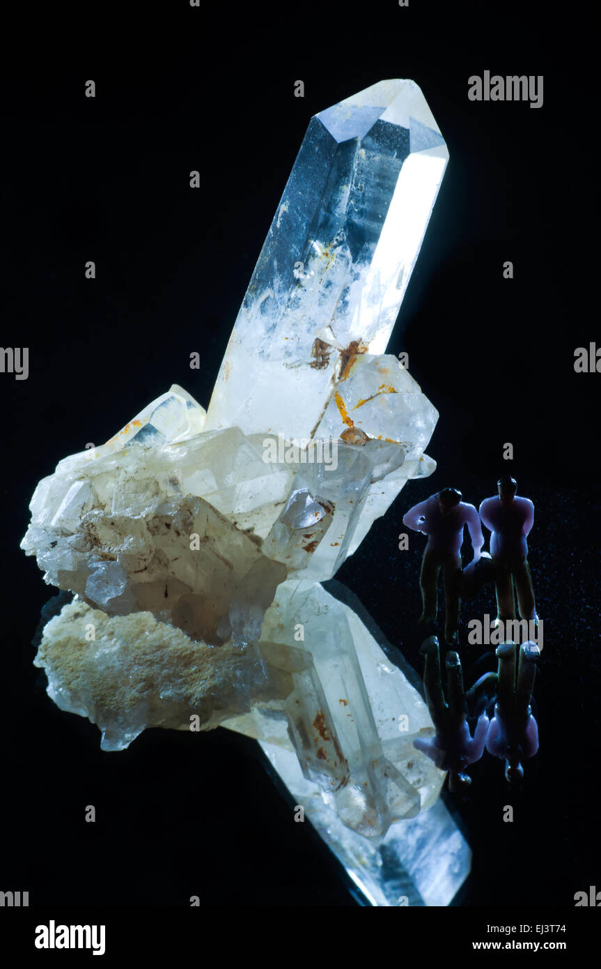 Cristallo di quarzo pietra minerale con effetti di illuminazione, mini figure e lo specchio in studio di impostazione Foto Stock