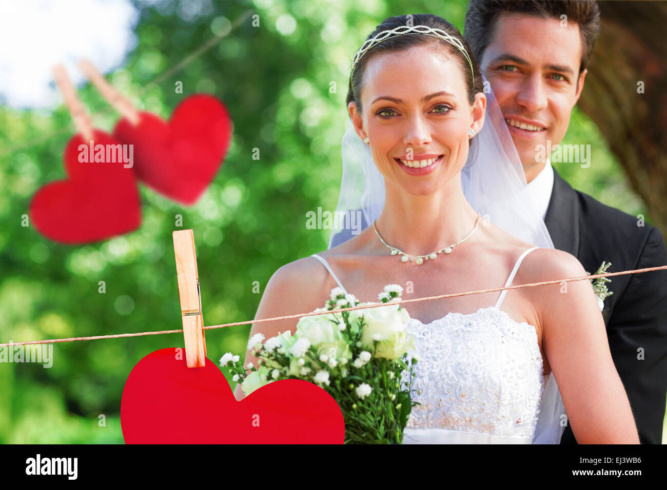 Immagine composita di sorridere sposa e lo sposo in giardino Foto Stock