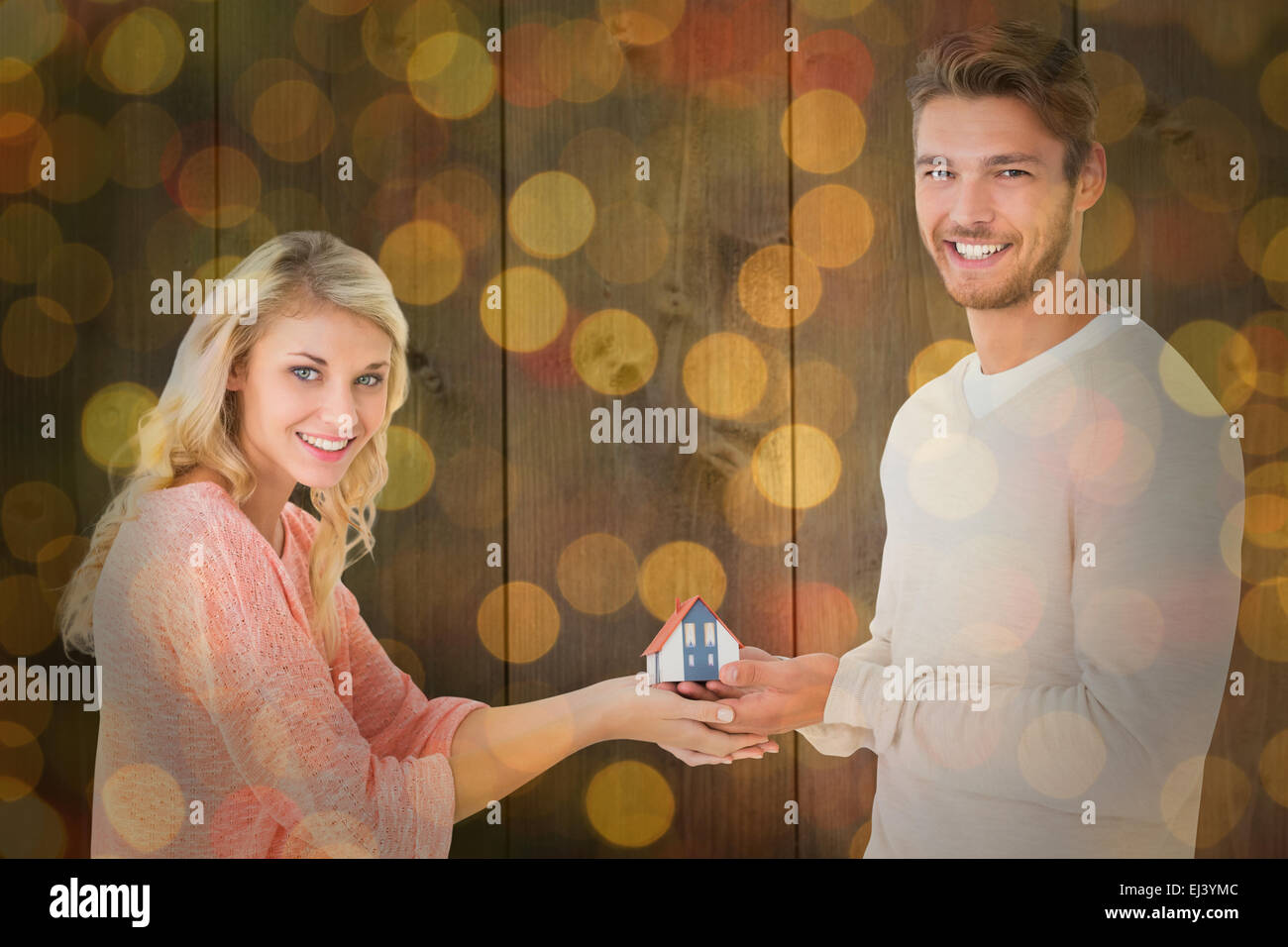 Immagine composita della coppia attraente tenendo in miniatura Modello di casa Foto Stock