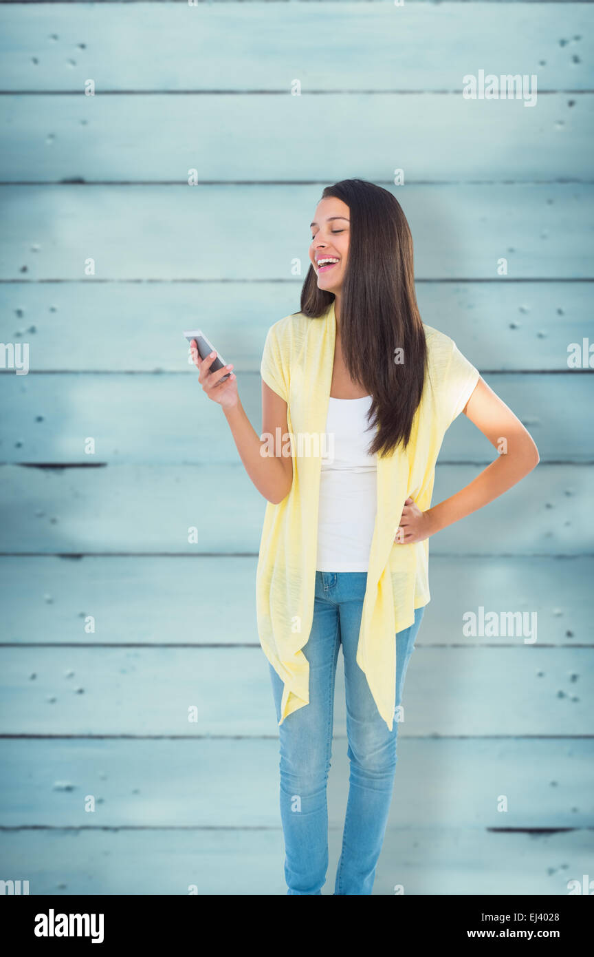 Immagine composita di felice donna informale l'invio di un testo Foto Stock