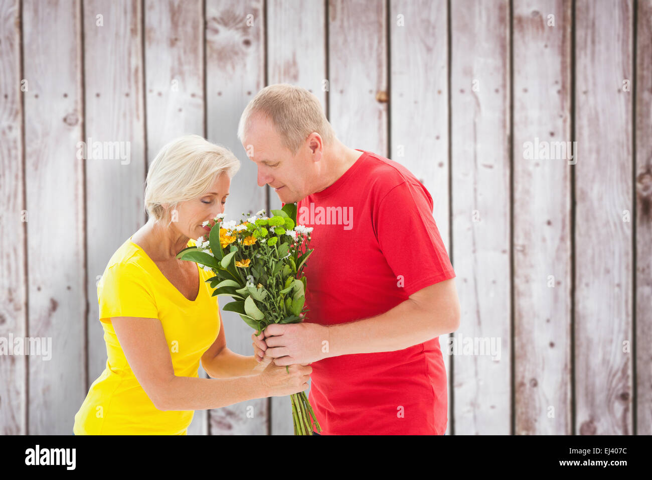 Immagine composita di uomo maturo che offre il suo partner fiori Foto Stock