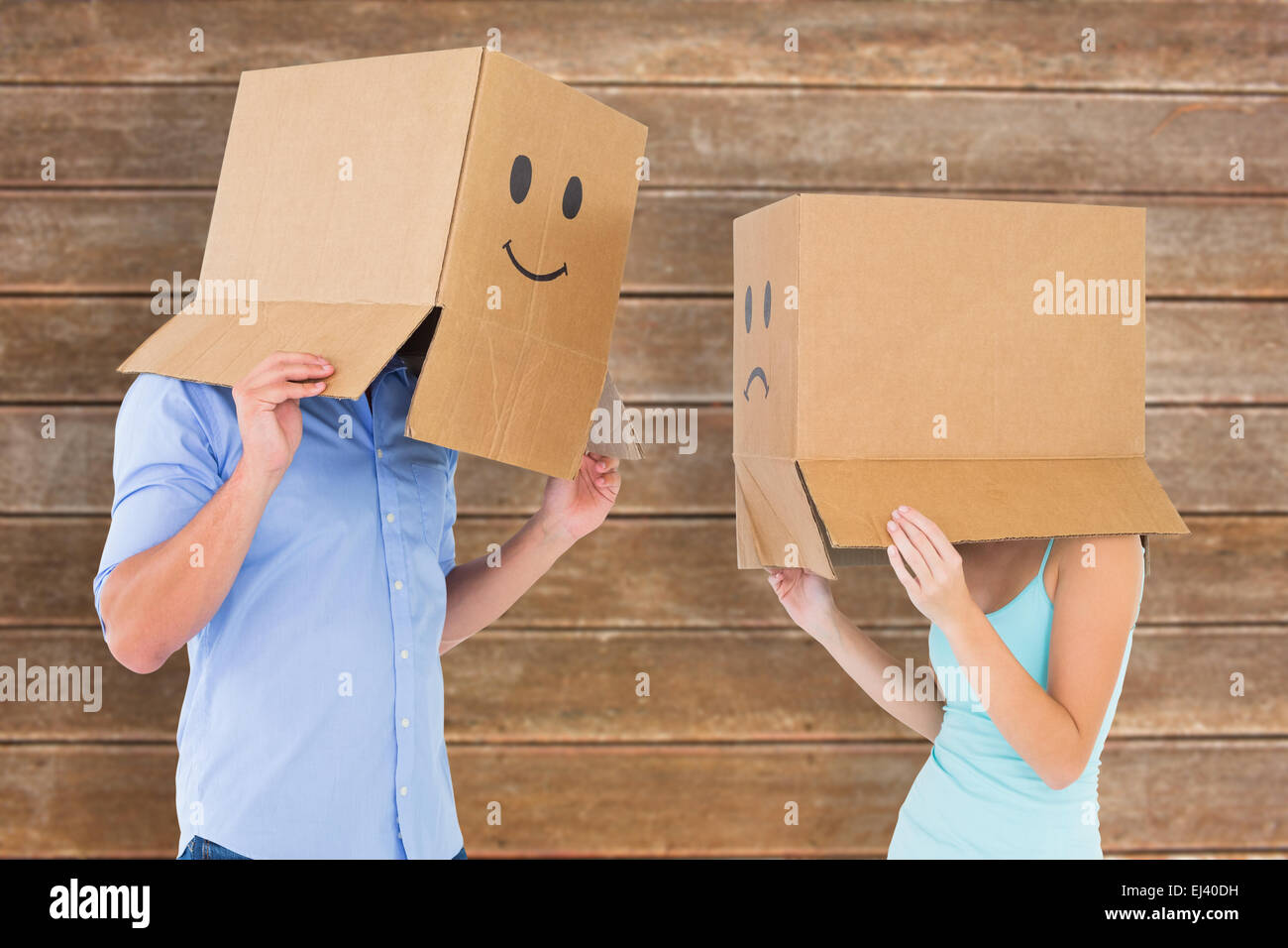 Immagine composita del giovane che indossa la faccia di emoticon scatole sulle loro teste Foto Stock