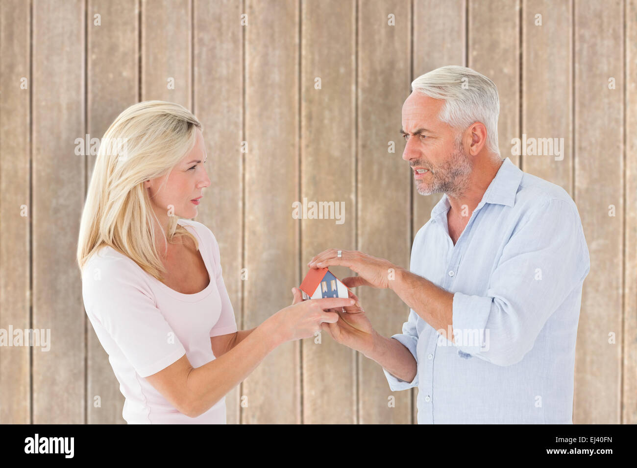 Immagine composita del giovane di lotta contro il modello in miniatura house Foto Stock