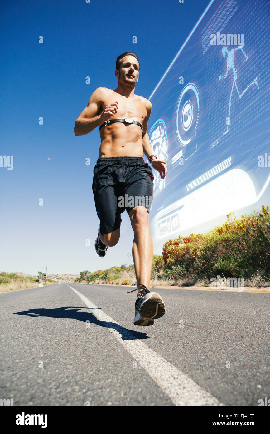 Immagine composita di atletica uomo jogging sulla strada aperta con monitor intorno al petto Foto Stock