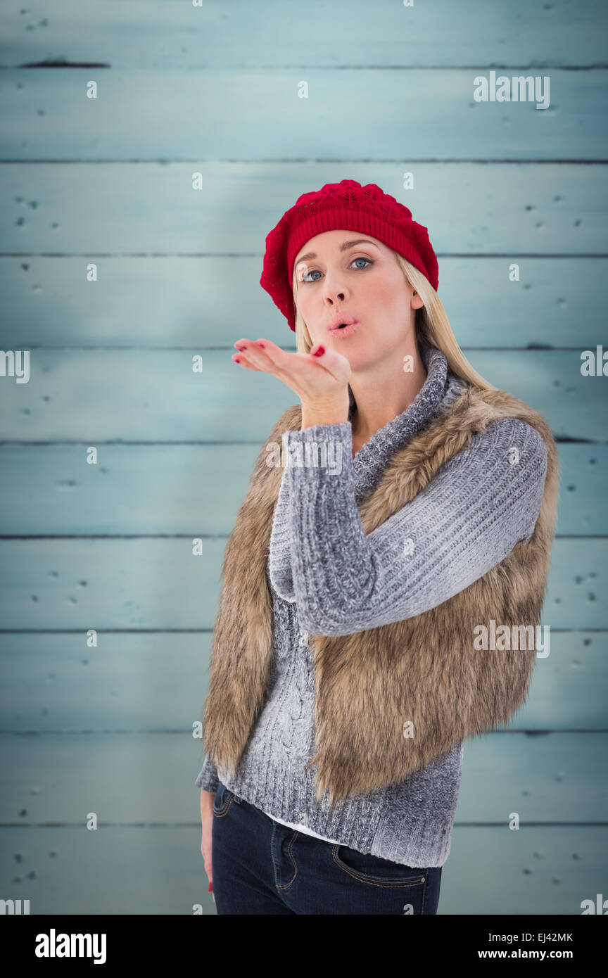 Immagine composita della bionda in inverno abiti bacio di soffiatura Foto Stock