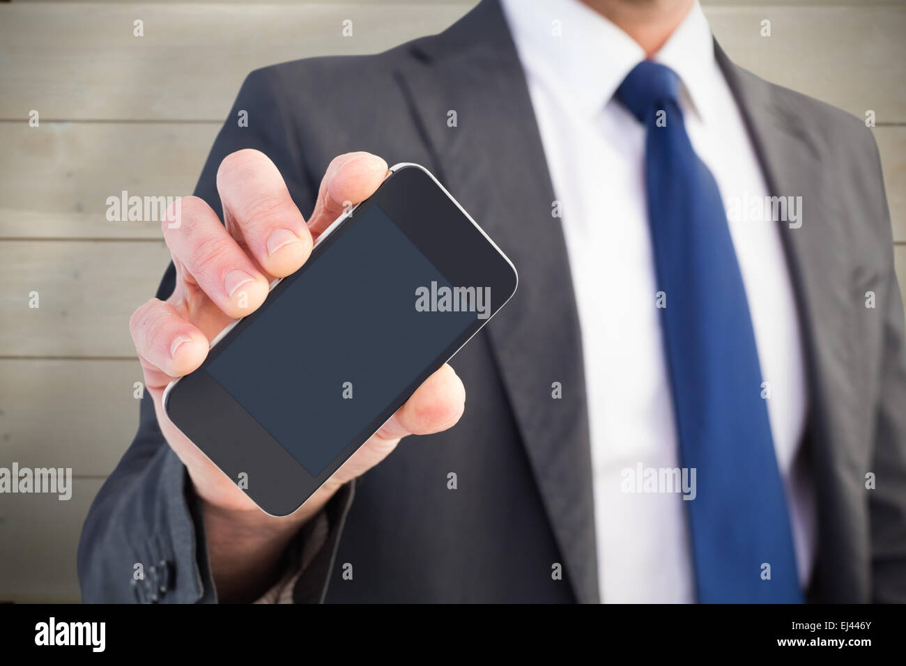 Immagine composita di imprenditore che mostra il suo lo schermo dello smartphone Foto Stock