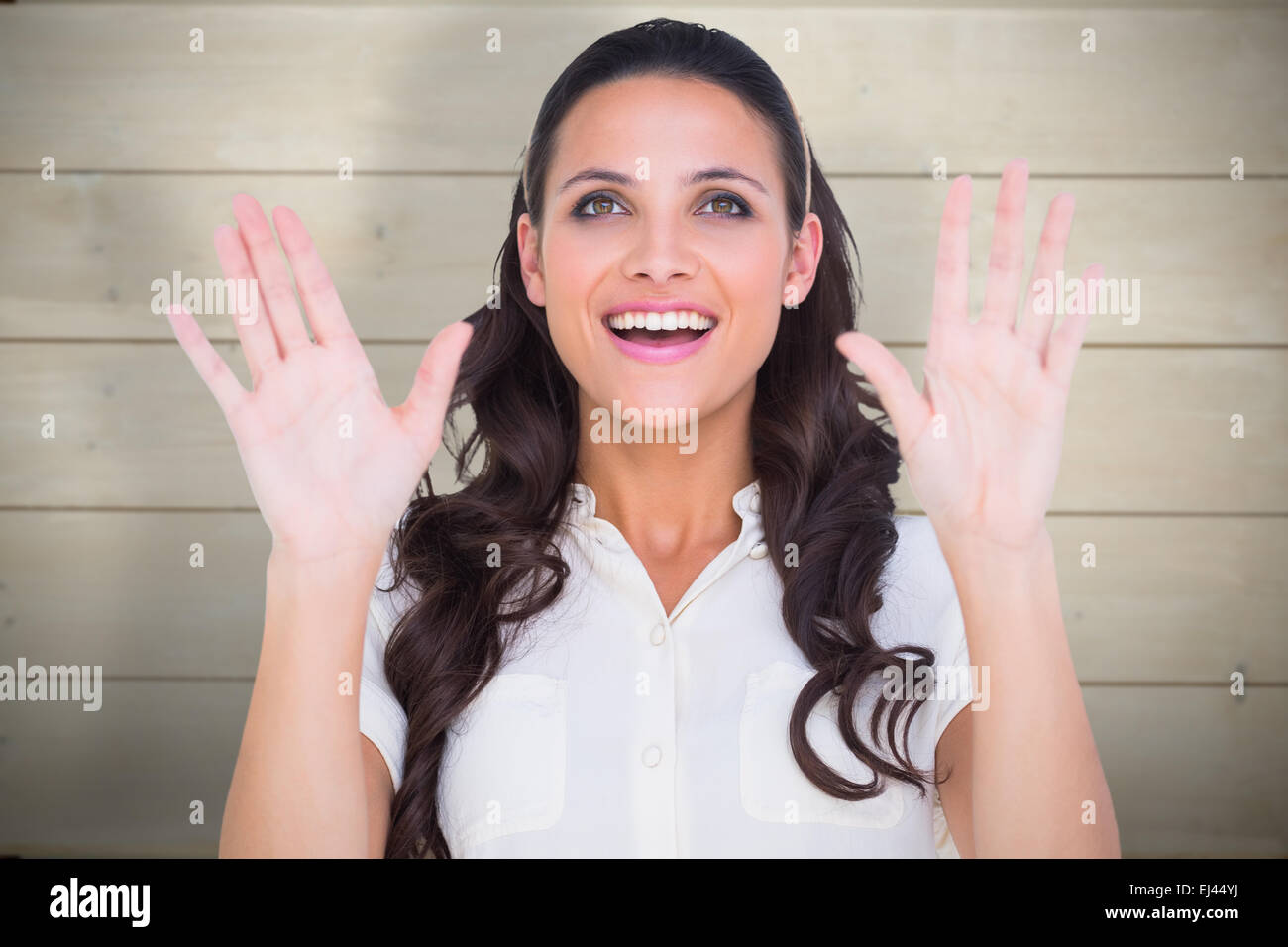 Immagine composita della bella bruna tenendo in alto le mani Foto Stock
