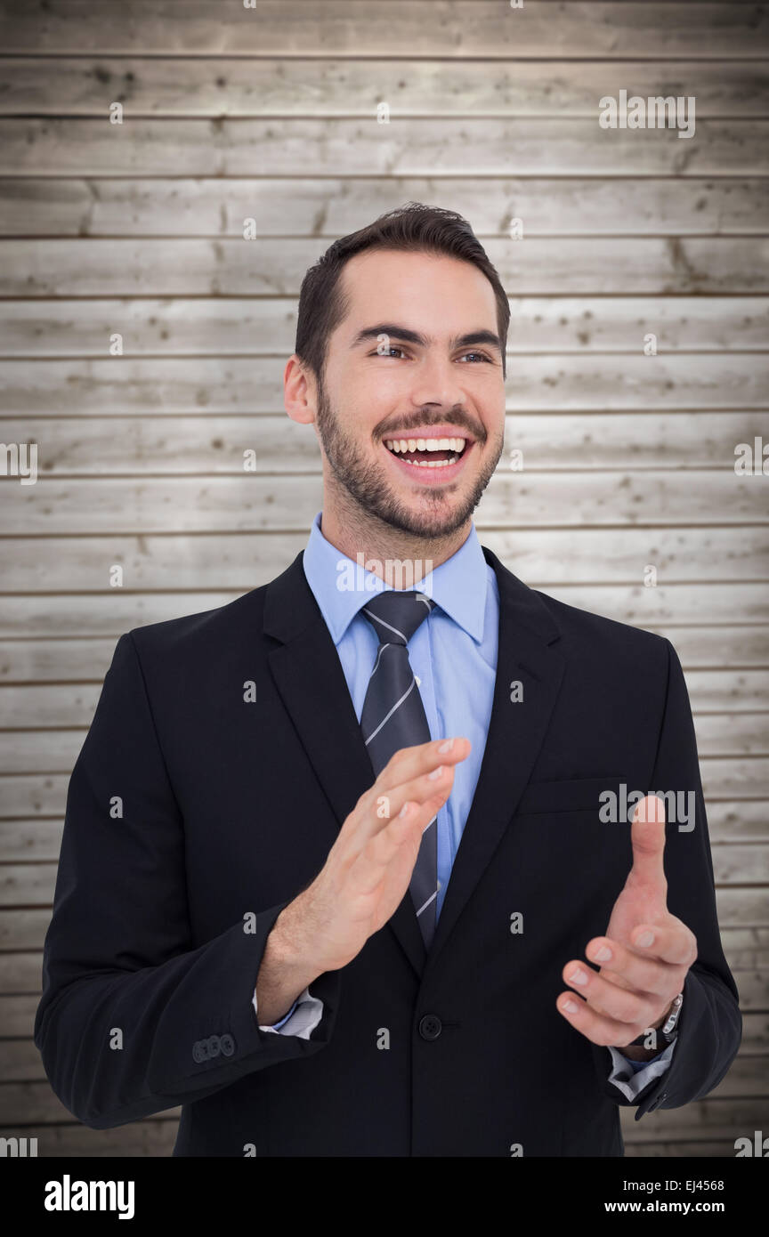 Immagine composita di happy businessman in piedi e battendo le mani Foto Stock
