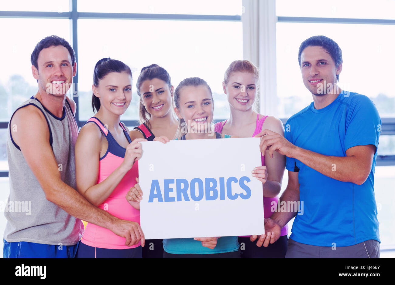 Aerobica contro il ritratto di un gruppo di classe fitness azienda carta bianca Foto Stock