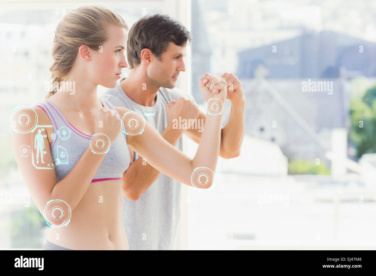 Immagine composita di grave giovane in piedi in atteggiamento di inscatolamento in studio fitness Foto Stock