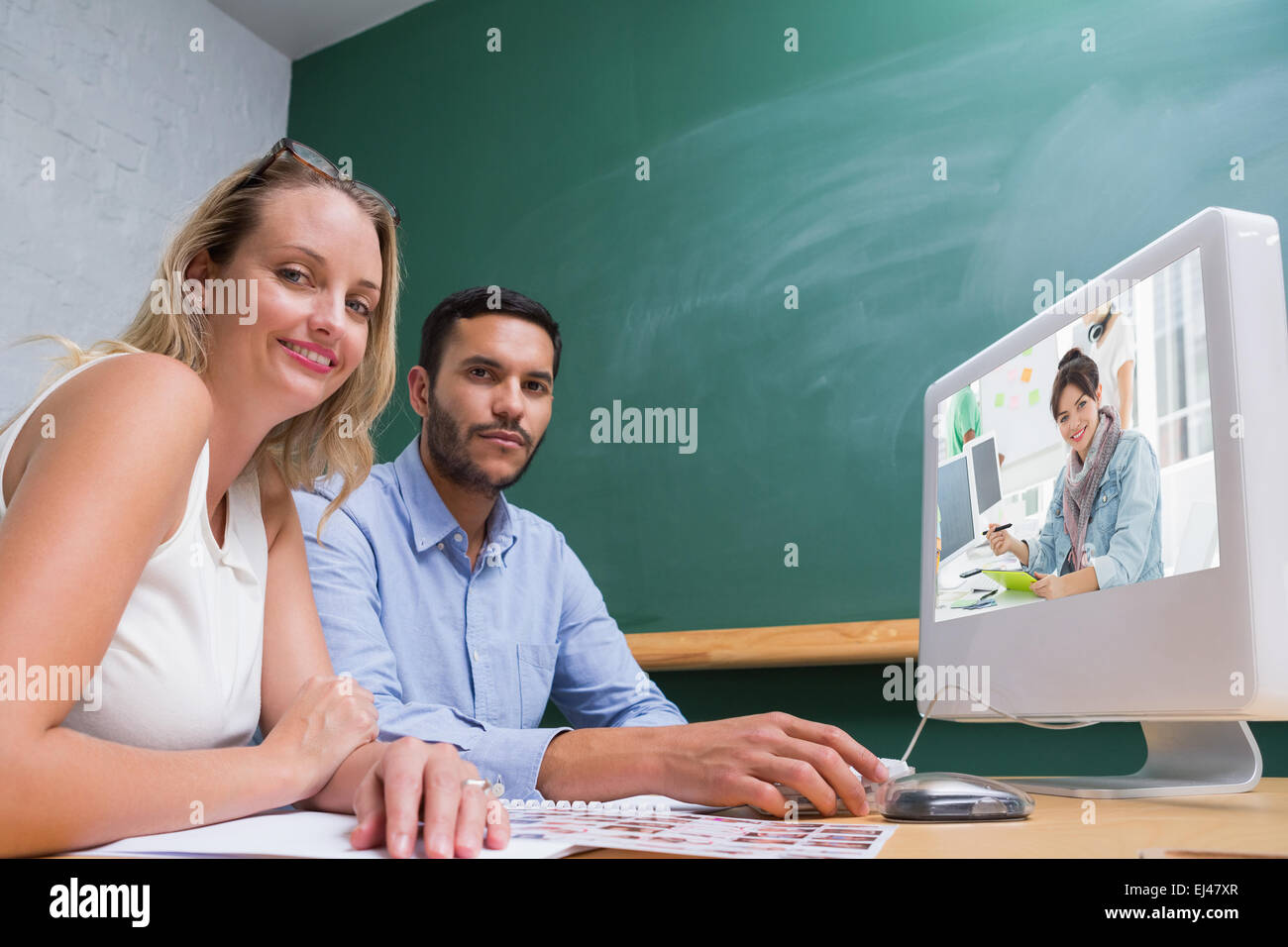 Immagine composita dell'artista disegno qualcosa sulla tavoletta grafica con i colleghi dietro Foto Stock