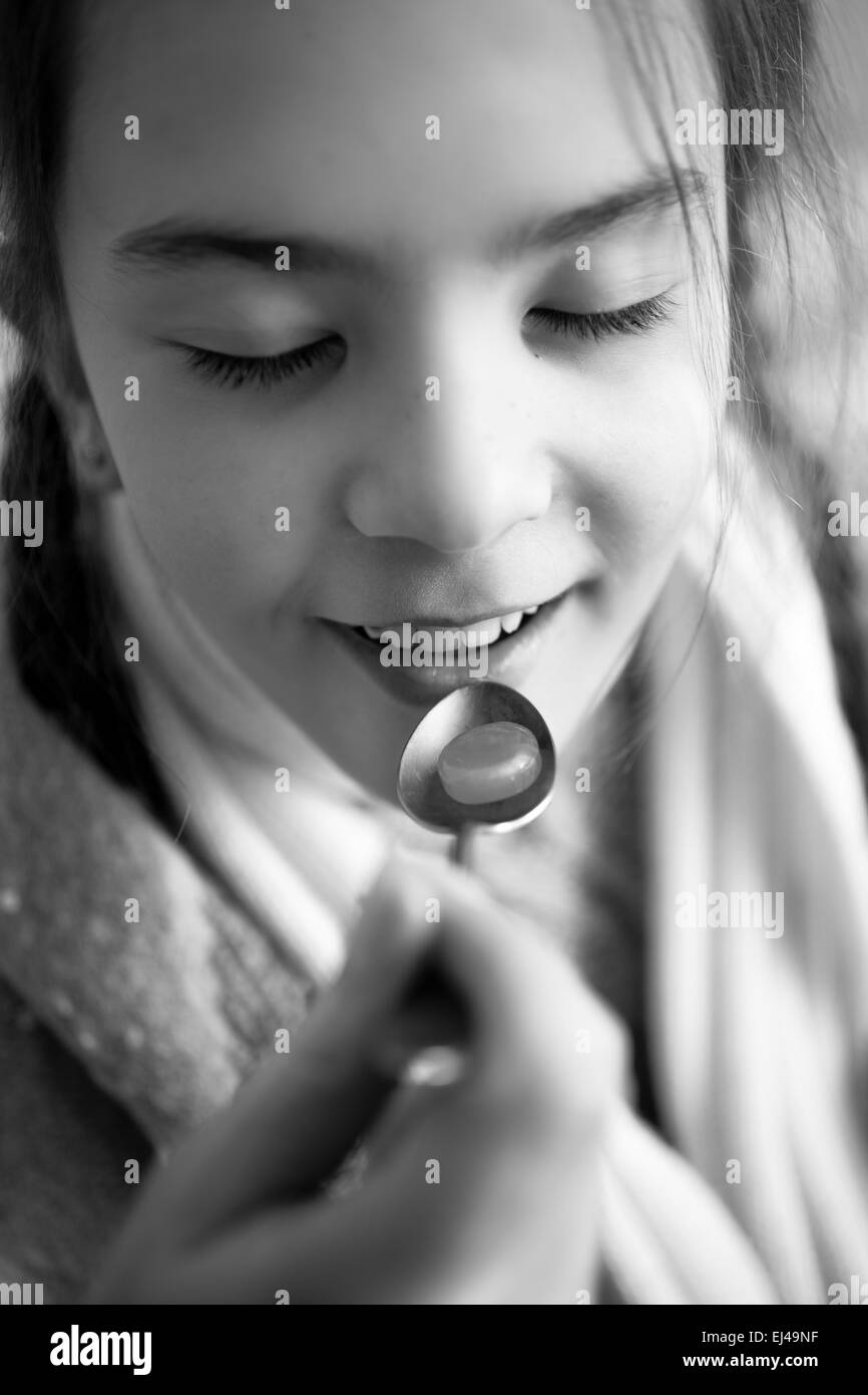 Foto in bianco e nero di piccola ragazza prendendo medicinali sul cucchiaio Foto Stock