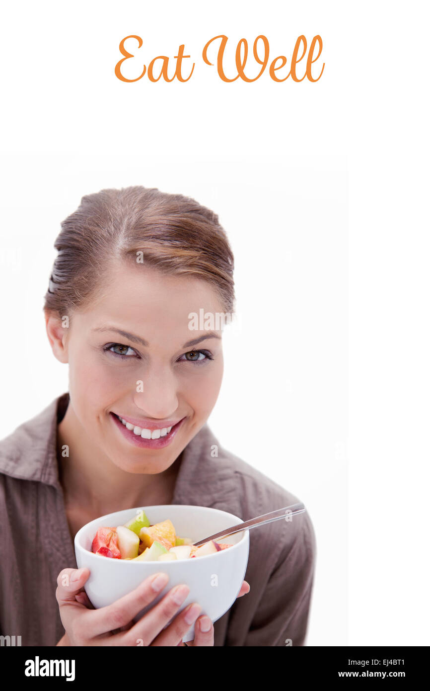 Mangiare bene contro la donna sorridente con ciotola di insalata di frutta Foto Stock