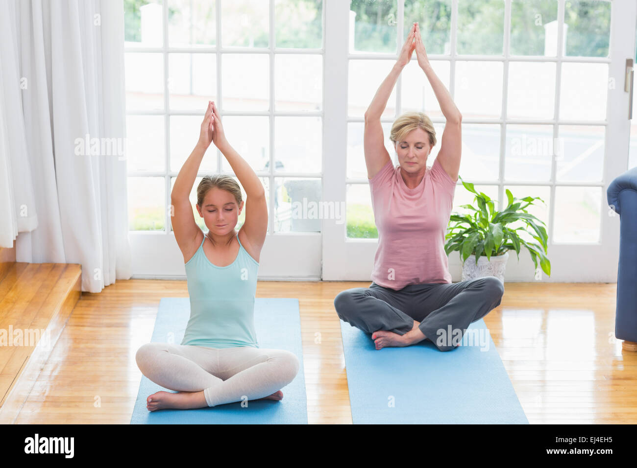 Madre e figlia fare yoga sul tappetino fitness Foto Stock