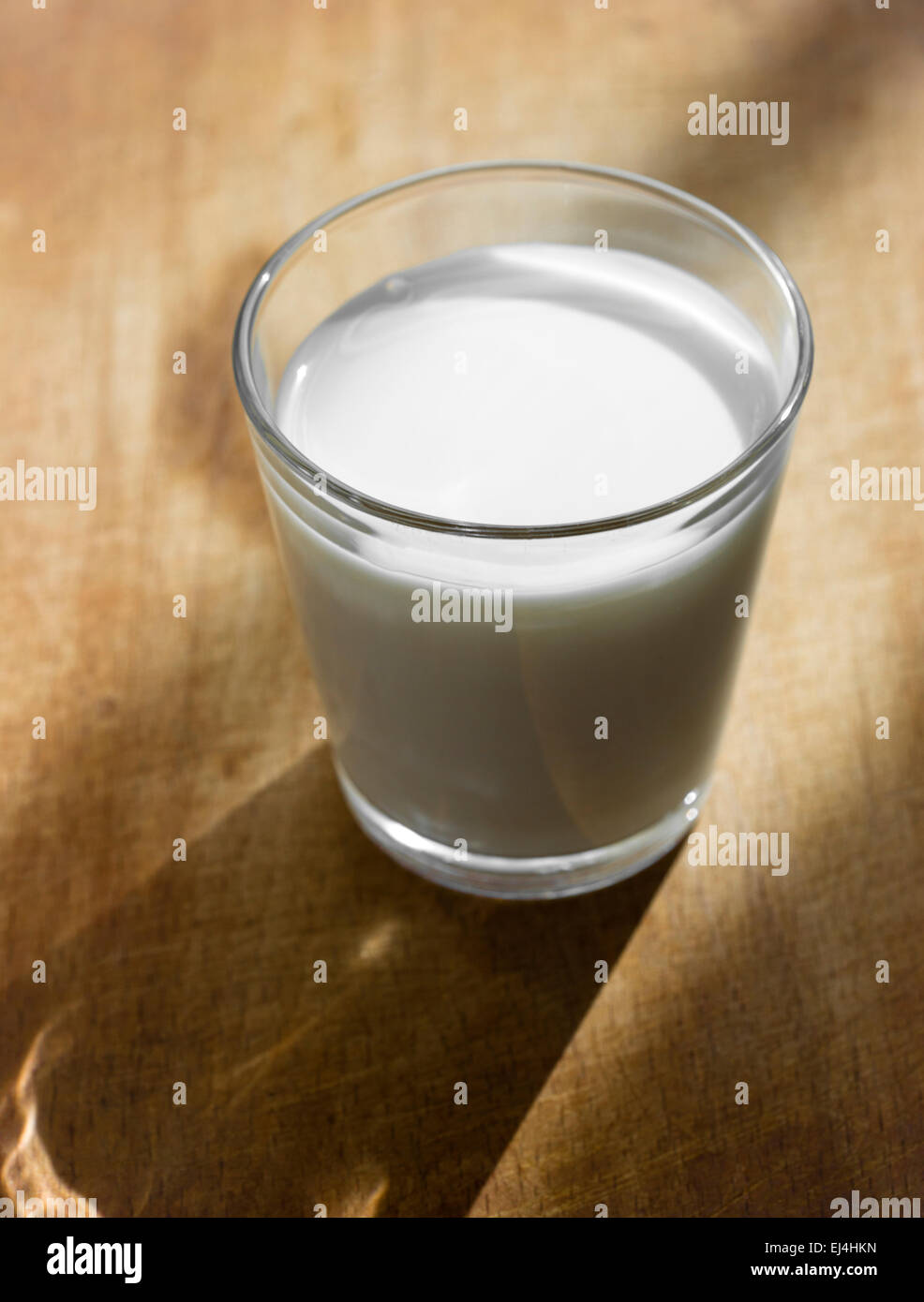 Un bicchiere di latte su sfondo di legno Foto Stock