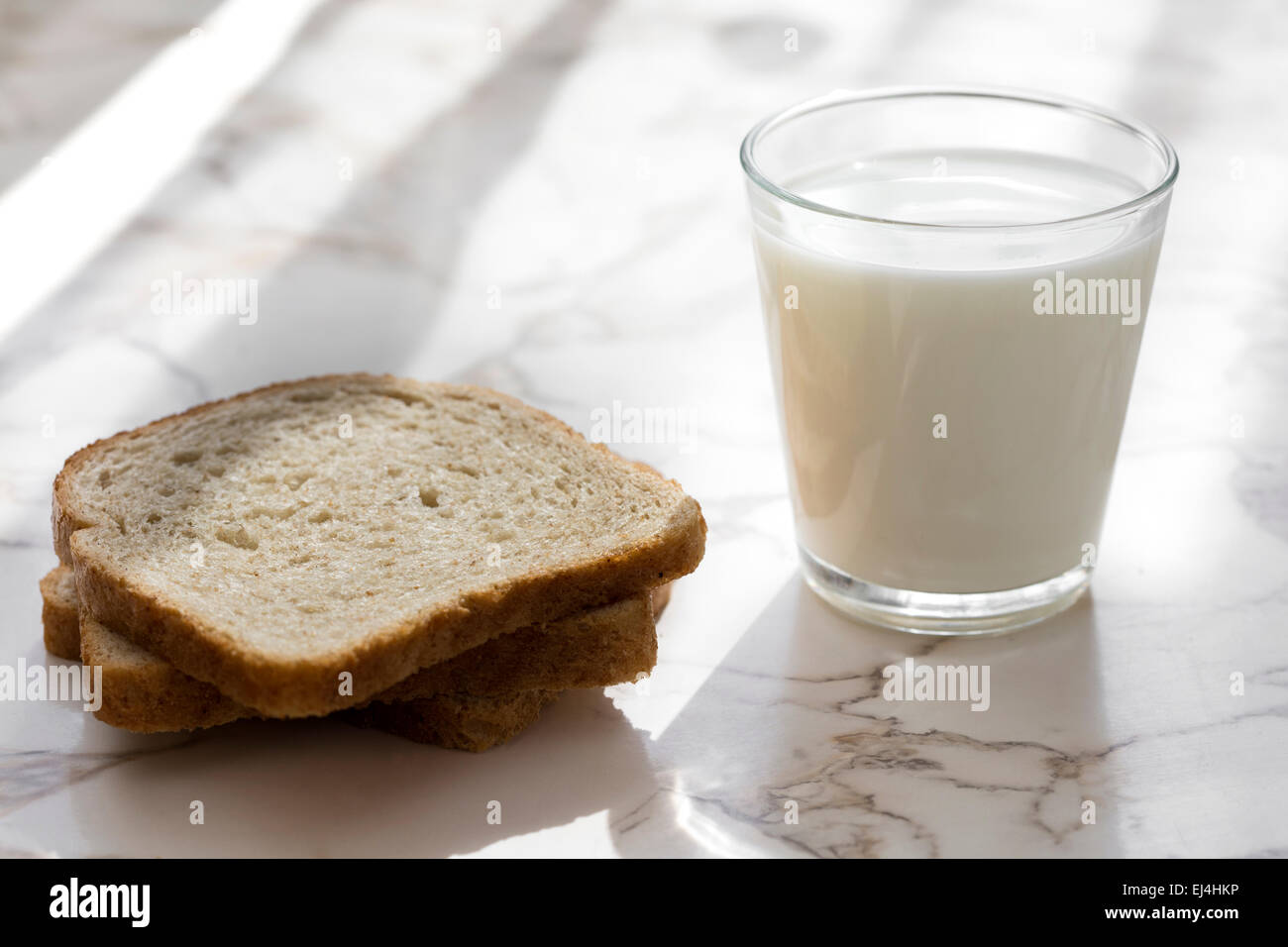 Un bicchiere di latte e pane scuro sul tavolo Foto Stock
